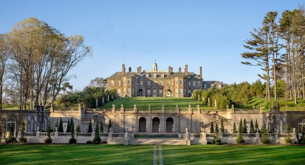 A view of the Great House at Castle Hill with green grass in front and blue sky in the background