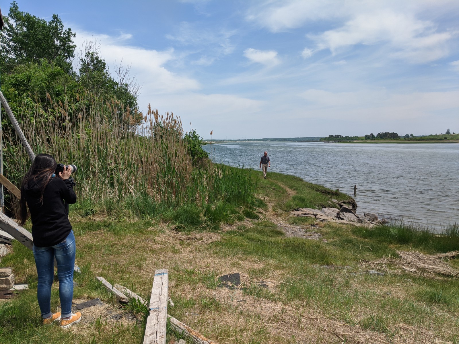 Woman taking photo of man walking up trail